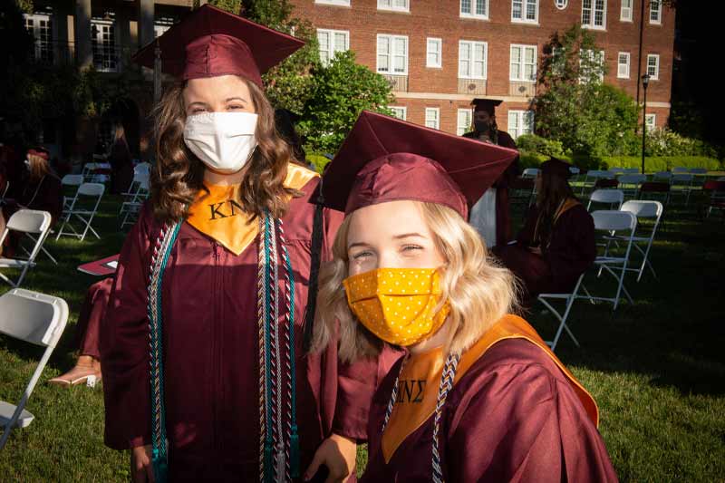 Students smiling behind masks at graduation