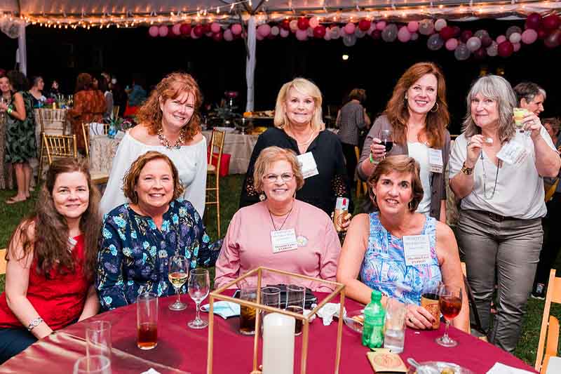 A group of alumnae smiling for a photo at the party.