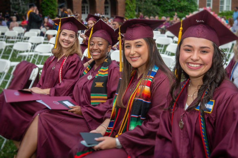 Four graduates smiling.