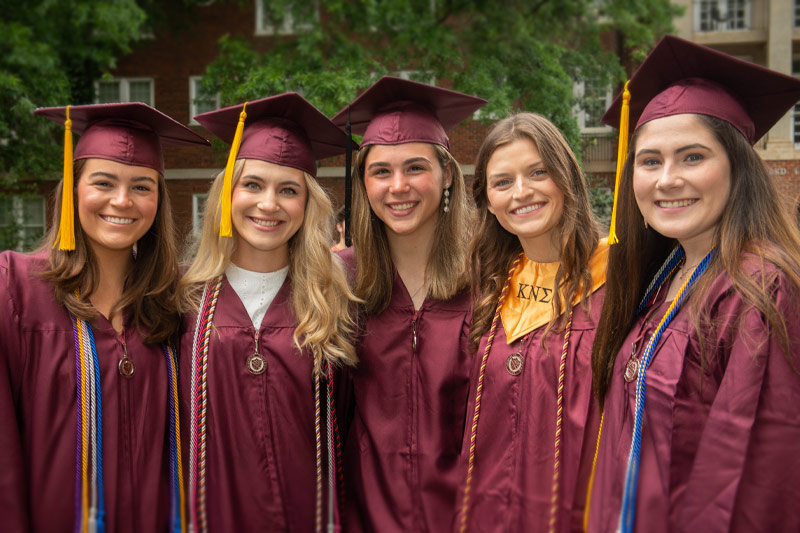 Five graduates smiling.
