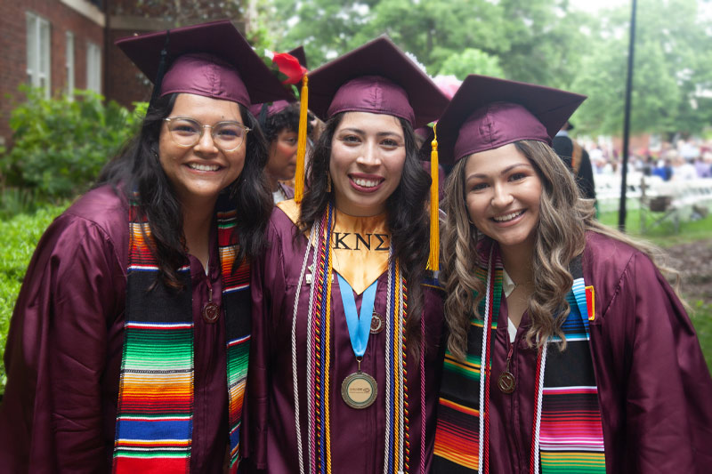 Three graduates smiling.