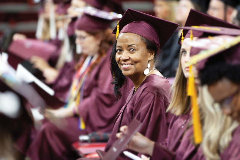 A wings student smiles at graduation.