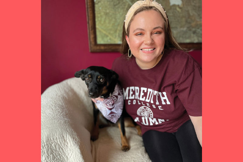 Katie Thompson with her her dog and a Meredith sweatshirt.