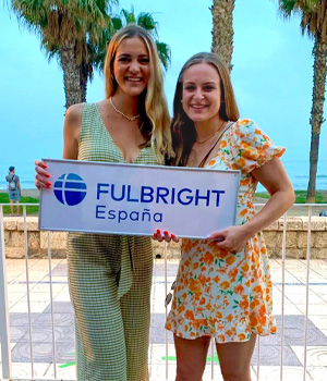 Two students hold a sign that says Fulbright España.