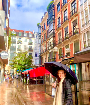 A student with an umbrella in a european city.