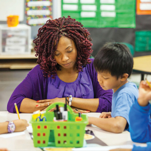 A education graduate works with young kids in her classroom.