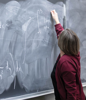 A student solves calculus on the chalkboard.