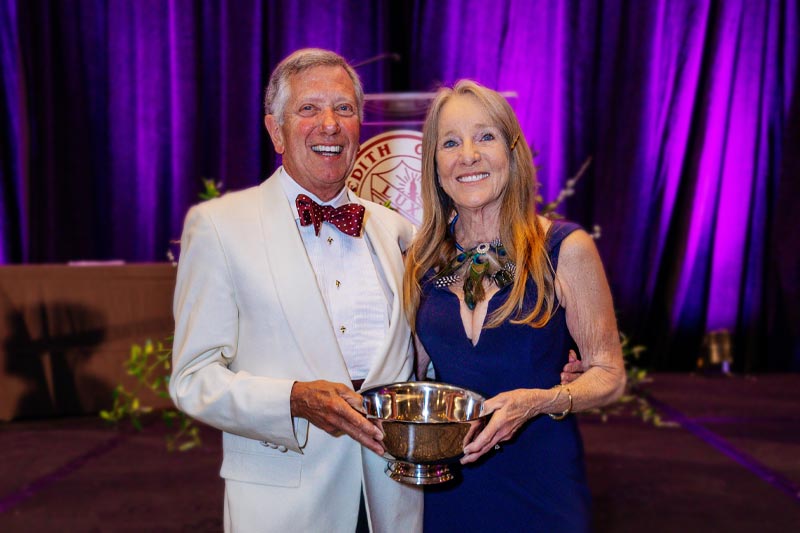 Two people smiling with their award from the philanthropy gala.